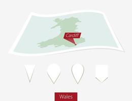 gebogen Papier Karte von Wales mit Hauptstadt Cardiff auf grau Hintergrund. vier anders Karte Stift Satz. vektor