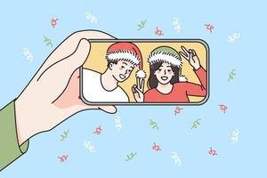 online Neu Jahr Feier Konzept. Mensch Hand halten Smartphone mit lächelnd Paar im Santa Hüte feiern und Gruß online Vektor Illustration