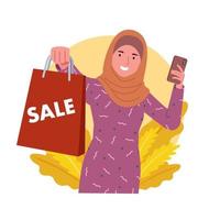 ein Frau tragen ein Hijab lächelt und zeigt an ein Papier Tasche Das sagt Verkauf während halten ihr Handy. vektor