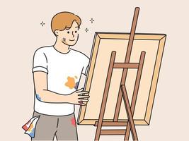 Lycklig ung man teckning bild på staffli. leende manlig konstnär målning njuter konst hobby eller fritid aktivitet. vektor illustration.