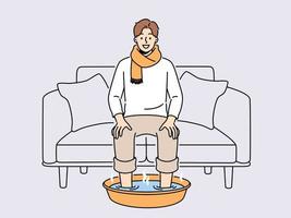 leende man i scarf sitta på soffa på Hem blöta fötter i varm vatten. Lycklig manlig lida från kall eller influensa do förfaranden för snabb återhämtning. sjukvård. vektor illustration.