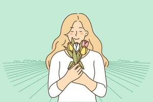 lächelnd Frau mit Strauß von Blumen gezupft beim Landschaft Plantage zum Konzept von Landwirtschaft und wachsend Tulpen. glücklich Mädchen mit geschlossen Augen atmet ein Blumen jubeln im Kommen von Frühling vektor