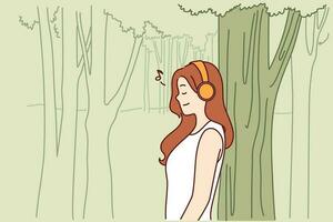 Frau hört zu zu Musik- durch Kopfhörer Stehen im Park in der Nähe von hoch Baum und genießen gut Wetter und frisch Luft. Teenager Mädchen hört zu zu Musik- entspannend allein im Natur nach schwer Tag beim Schule vektor