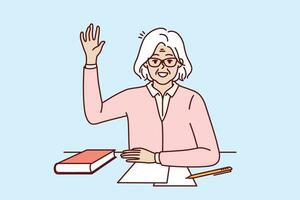 glücklich Alten Frau Schüler sitzt beim Schule Schreibtisch mit Buch und erhöht Hand oben wollen zu Fragen Frage zu Lehrer. lebensfähig positiv Rentner Schüler bekommen Bildung nach Pensionierung vektor