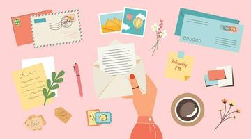 kvinna hand innehav öppen kuvert med skrivning brev. stämplar, vykort, Foto kort, klistermärken och en kopp av kaffe topp se rosa bakgrund vektor