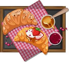 Frühstückscroissant mit Erdbeermarmelade auf einem Holzteller isoliert vektor