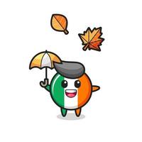 Cartoon des niedlichen Irland-Flaggenabzeichens, das im Herbst einen Regenschirm hält vektor
