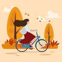 eine Frau, die Fahrrad in der Herbstlandschaft fährt vektor