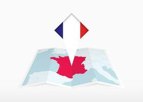 Frankreich ist abgebildet auf ein gefaltet Papier Karte und festgesteckt Ort Marker mit Flagge von Frankreich. vektor