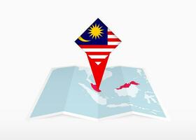 Malaysia ist abgebildet auf ein gefaltet Papier Karte und festgesteckt Ort Marker mit Flagge von Malaysia. vektor