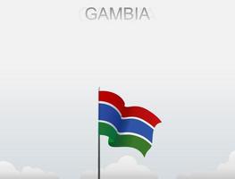 Die Gambia-Flagge weht an einem Mast, der hoch unter dem weißen Himmel steht vektor