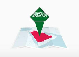 saudi arabien är avbildad på en vikta papper Karta och fästs plats markör med flagga av saudi arabien. vektor