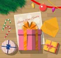 brev från santa claus. trä- skrivbord med gåva lådor, polkagris, kuvert, glas bollar och päls grenar. lyckönskningar och presenterar på jul och ny år eve. vektor illustration i platt stil