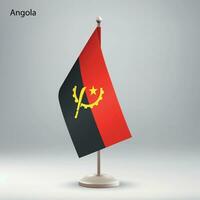 Flagge von Angola hängend auf ein Flagge Stand. vektor