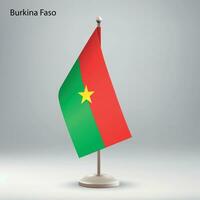 Flagge von Burkina Faso hängend auf ein Flagge Stand. vektor