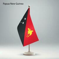 flagga av papua ny guinea hängande på en flagga stå. vektor