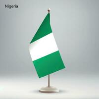 flagga av nigeria hängande på en flagga stå. vektor