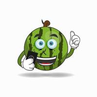 vattenmelon maskot karaktär som håller en mobiltelefon. vektor illustration