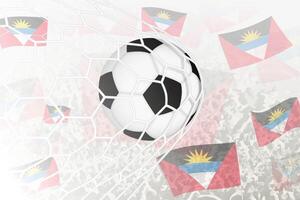 National Fußball Mannschaft von Antigua und Barbuda erzielte Ziel. Ball im Tor Netz, während Fußball Unterstützer sind winken das Antigua und Barbuda Flagge im das Hintergrund. vektor