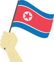 hand innehav och höjning de nationell flagga av norr korea vektor