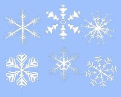 uppsättning jul snöflingor på en blå bakgrund vektor