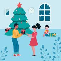 familj nära julgranen i vardagsrummet. en man ger en gåva till en kvinna. ett barn i bakgrunden tar en present från en låda. hälsningssäsongen vektor