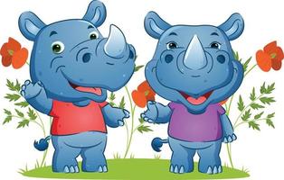 paret glada noshörningar som viftar med handen och ger det glada leendet i trädgården vektor