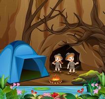 Cartoon-Kinder im Explorer-Outfit campen in der Nähe der Höhle vektor