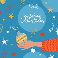 weihnachtsgrußkarte dekoriert mit konfetti, kugel in menschlicher hand. weibliche hand, die weihnachtsbaumdekoration verziert oder hält. flache karikaturillustration des vektors vektor