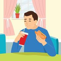 Mann isst Hotdog und trinkt Limonade im Wohnzimmer. Charakter, der Junk Food isst