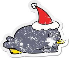 Pinguin liegt auf dem Bauch und trägt eine Weihnachtsmütze vektor