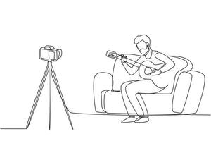 enda en rad ritning arabisk man spelar in video av sin gitarrspelning med kamera på stativ. manlig vlogger-influencer som framför musik för show till digital streaming. kontinuerlig linje rita design vektor