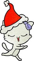 strukturierter Cartoon einer Katze mit Schleife auf dem Kopf mit Weihnachtsmütze vektor