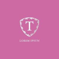 t bokstav första logotyp formgivningsmall. lämplig för försäkring, mode och skönhetsprodukter. lyxig silver dekorativ blommig sköldillustration. isolerad på rosa färgbakgrund. vektor