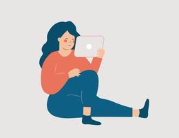 ung kvinna sitter och spenderar tid på att arbeta online hemma. tonårsflicka kommunicerar med vänner via sociala medier och tittar på videor på sin surfplatta. frilanskoncept. vektor lager.