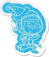 glad tecknad nödställd klistermärke av en astronaut som bär tomtehatt vektor