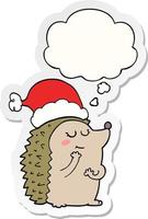 Cartoon-Igel mit Weihnachtsmütze und Gedankenblase als gedruckter Aufkleber vektor