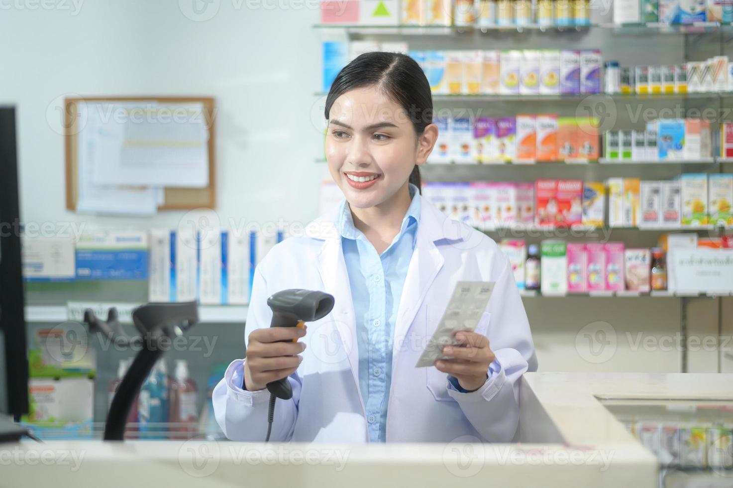 pharmacienne scannant le code-barres sur une boîte à médicaments dans une pharmacie de pharmacie moderne. photo