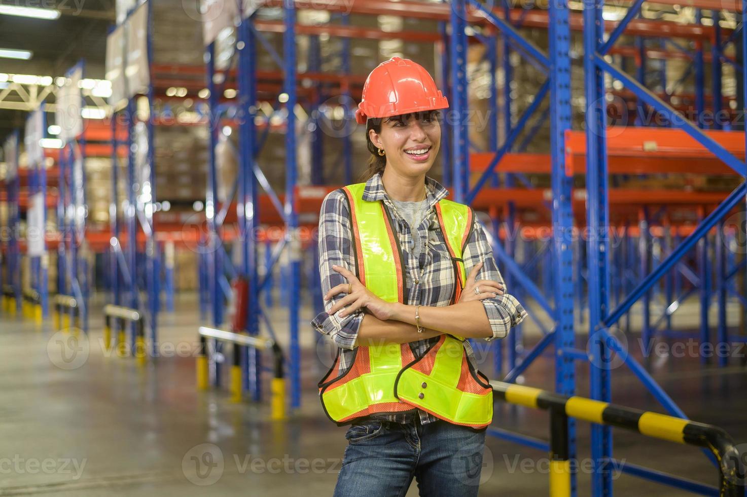 portrait d'une jeune travailleuse métisse portant un casque dans un entrepôt moderne d'un magasin de détail photo