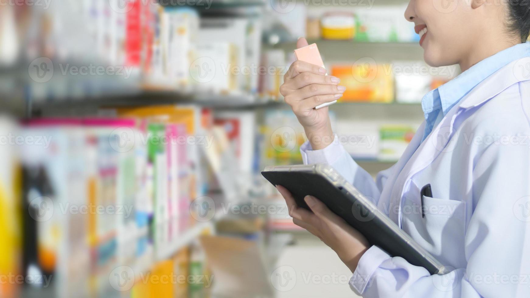 portrait d'une pharmacienne à l'aide d'une tablette dans une pharmacie de pharmacie moderne. photo