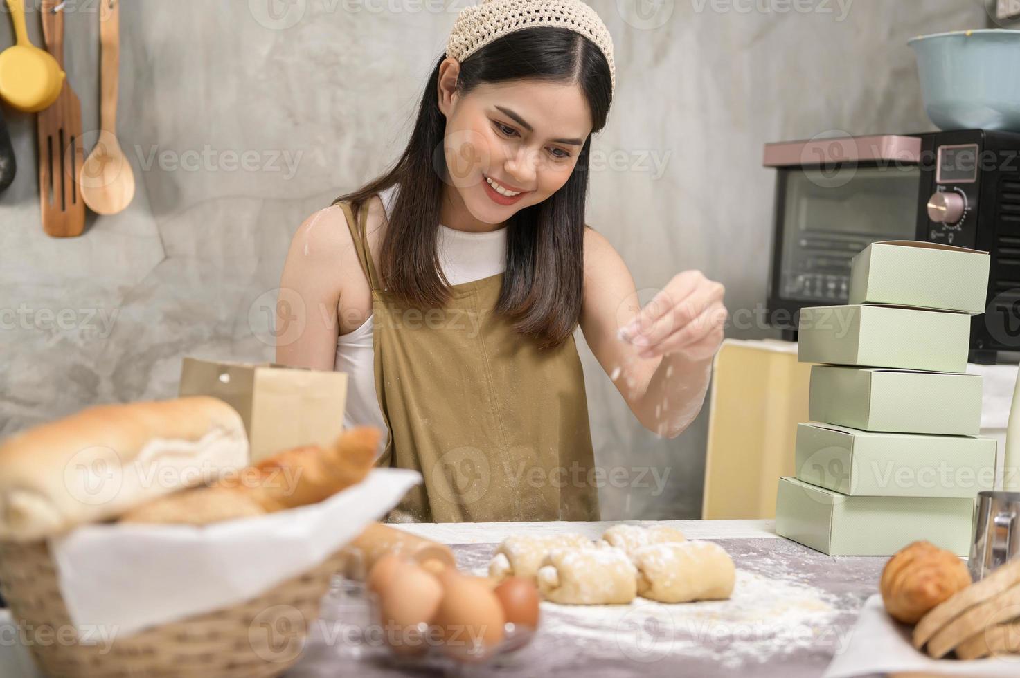 belle jeune femme cuisine dans sa cuisine, sa boulangerie et son café photo