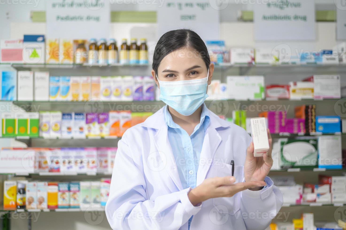 portrait d'une pharmacienne portant un masque facial dans une pharmacie de pharmacie moderne. photo