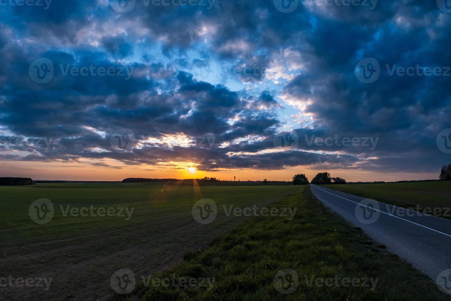 paysage de champ vert avec ciel du soir bleu rouge rose avec de beaux nuages après le coucher du soleil photo