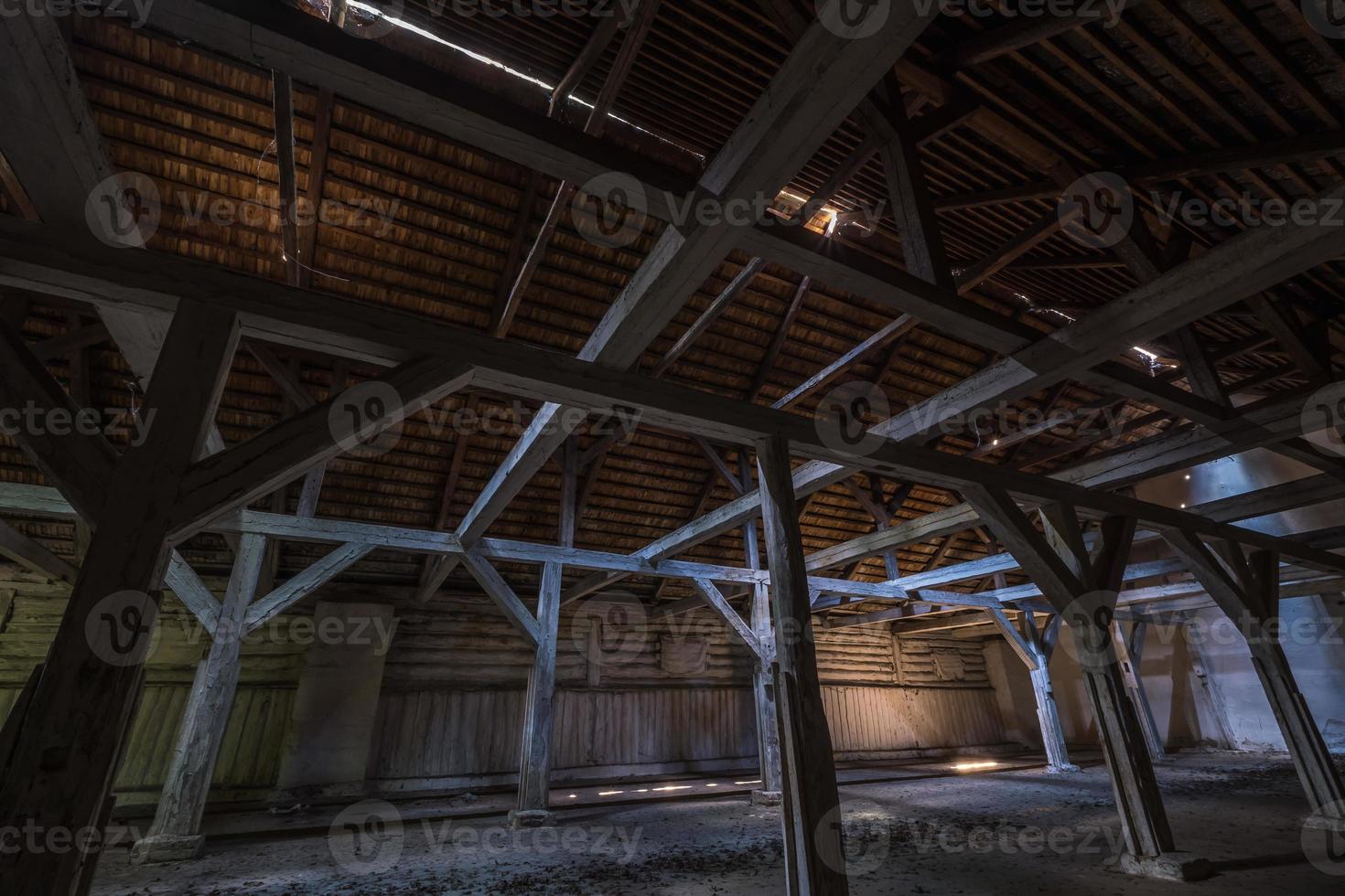 à l'intérieur d'un hangar en bois en ruine abandonné sombre avec des colonnes en décomposition photo