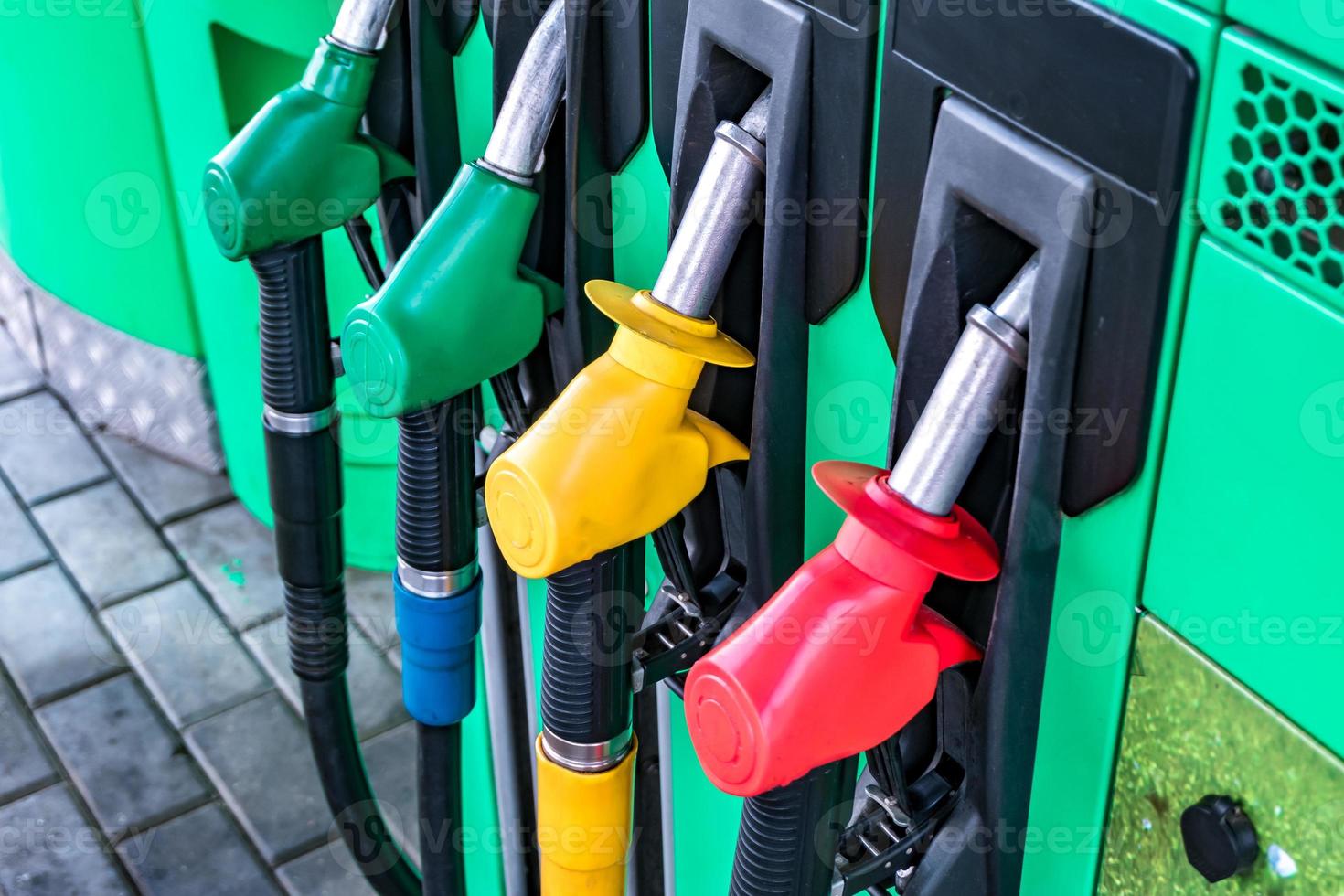 gaz et station essence. pistolets pour faire le plein dans une station-service. détail d'une pompe à essence de différentes couleurs dans une station-service. gros plan sur l'injecteur de carburant dans le distributeur d'huile avec essence et diesel photo