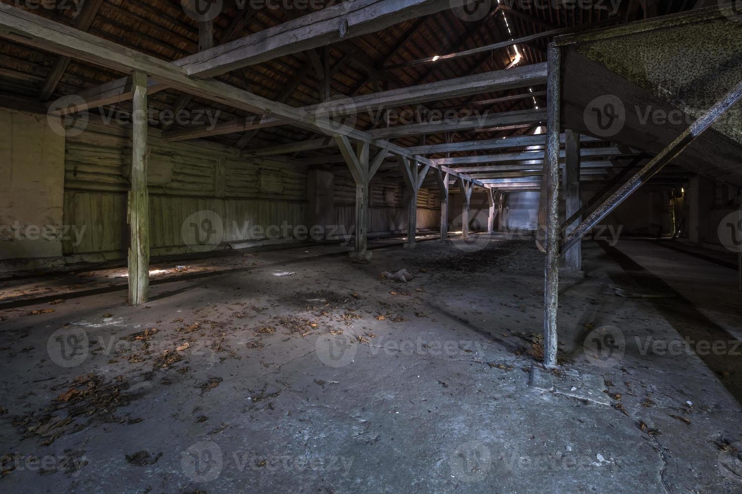 à l'intérieur d'un hangar en bois en ruine abandonné sombre avec des colonnes en décomposition photo
