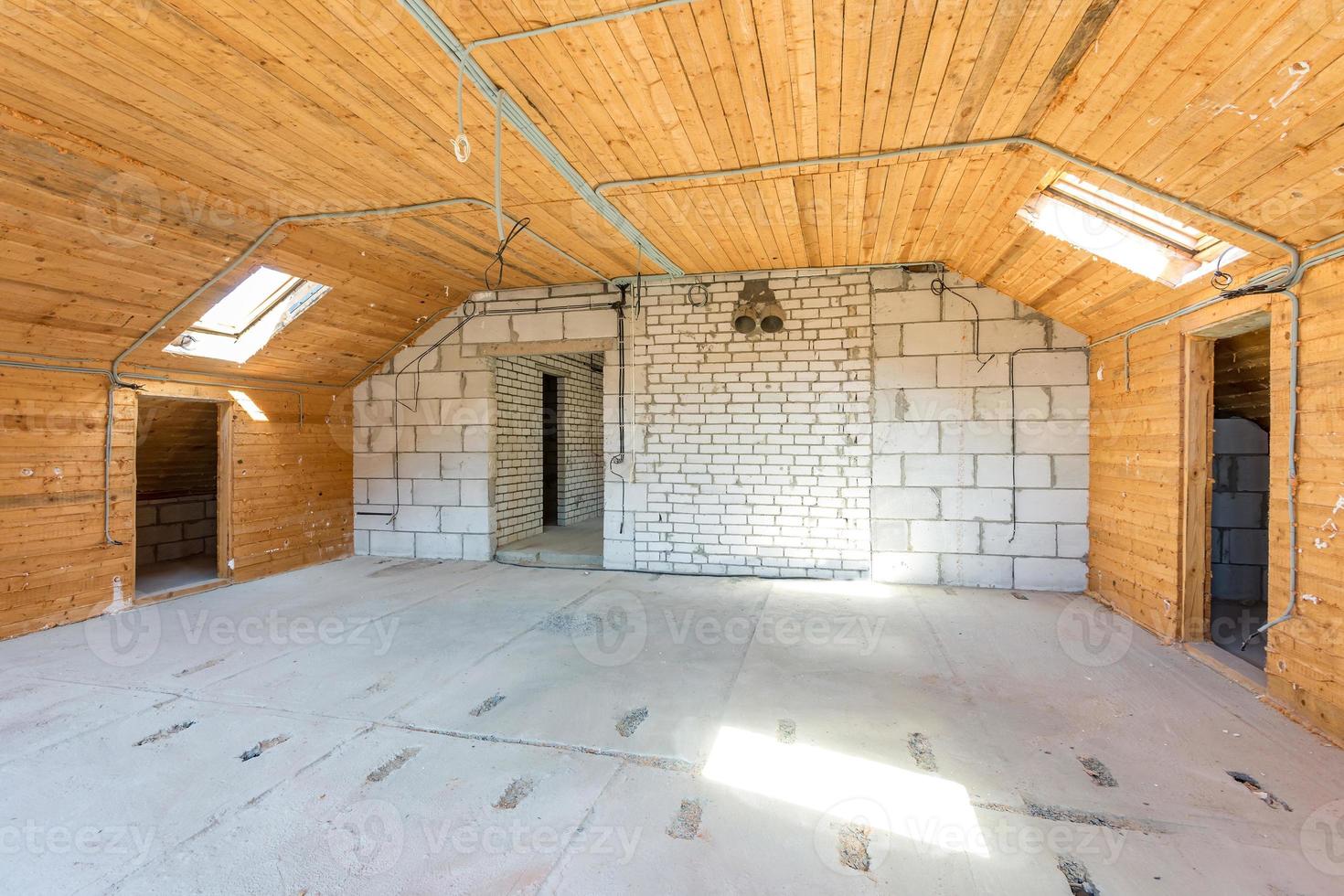 intérieur vide dans la maison sans réparation sur sol mansardé en bois et mur de briques photo