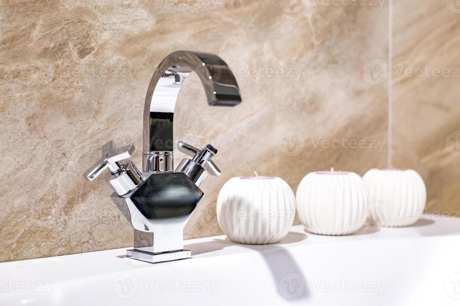 Lavabo du robinet d'eau avec robinet avec des bougies dans la salle de bains loft cher photo