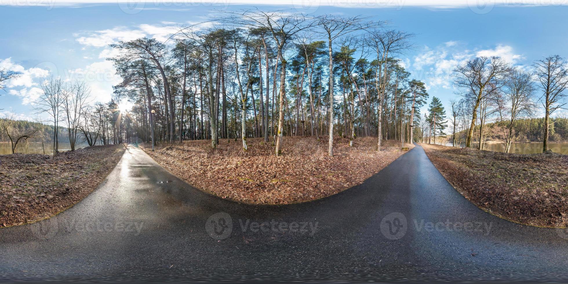 panorama hdri sphérique complet vue d'angle à 360 degrés sur le sentier piétonnier asphalté et la piste cyclable dans la forêt de pins près de la rivière en projection équirectangulaire. contenu vr ar photo