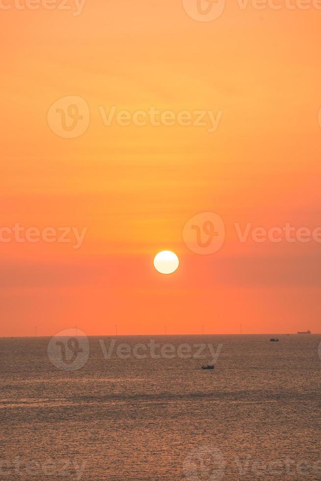 beau paysage de plage au coucher du soleil, nature exotique de l'île tropicale, ciel rouge jaune coloré, bateau silhouette, reflet doré du soleil, vacances d'été. cinématique de nuage de ciel. photo